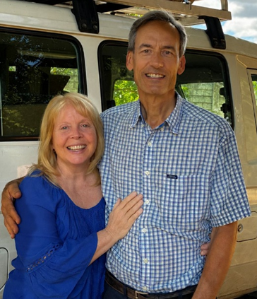 Ken and Sue Sawka standing together in front of their vehicle