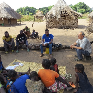 Ken and Pastor Gerald teaching villagers how to do a Bible study with an audio Bible