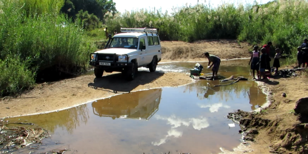 Vehicle crossing a stream during a trip to the Kunda people in Zambia