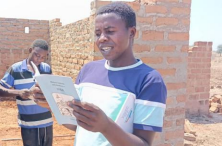 Young man reading the Gospel of Luke printed in Toka-Leya